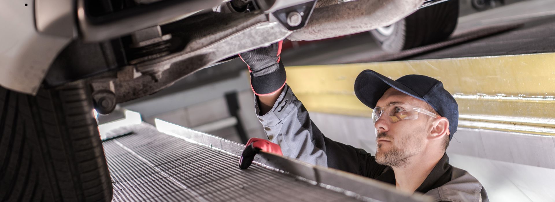 Man in workshop working underneath a car